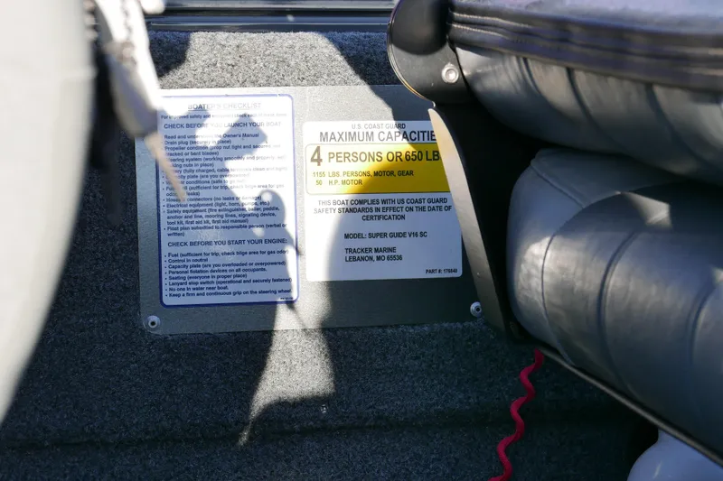 Slide: The Image of 2018 Tracker Super Guide V-16 capacity label, seating, and safety checklist in boat interior. - 9