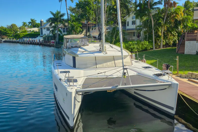 The Image of 2017 Fountaine Pajot Lucia 40 catamaran docked by a scenic waterfront. - 0