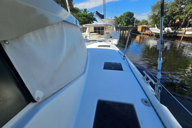 Slide: The Image of 2017 Fountaine Pajot Lucia 40 catamaran docked by a serene waterfront. - 11