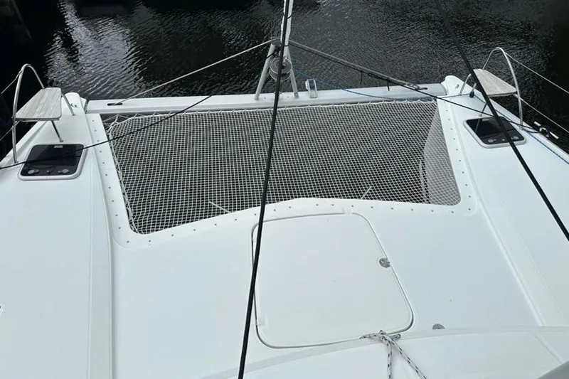 Slide: The Image of 2017 Fountaine Pajot Lucia 40 catamaran deck with netting over water. - 14