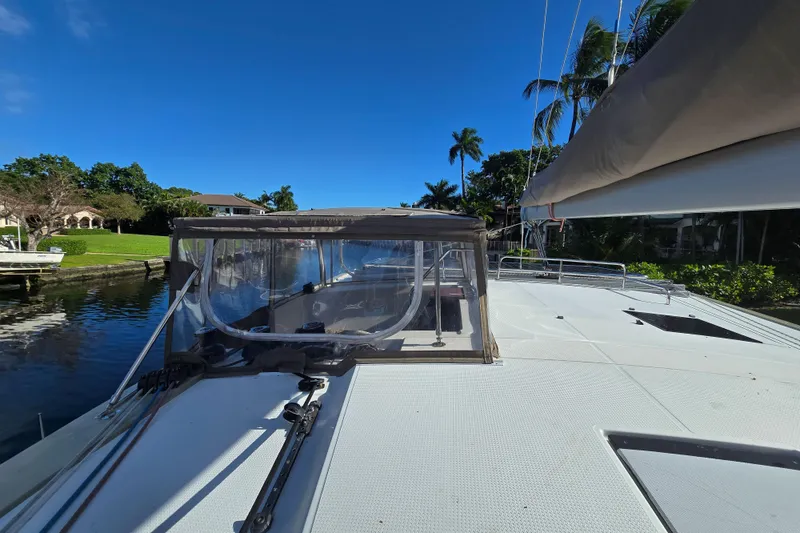 Slide: The Image of 2017 Fountaine Pajot Lucia 40 catamaran docked by lush greenery and clear blue sky. - 18
