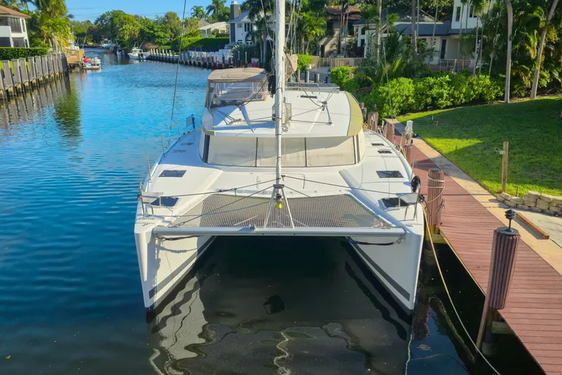Slide: The Image of 2017 Fountaine Pajot Lucia 40 catamaran docked in a scenic canal setting. - 2