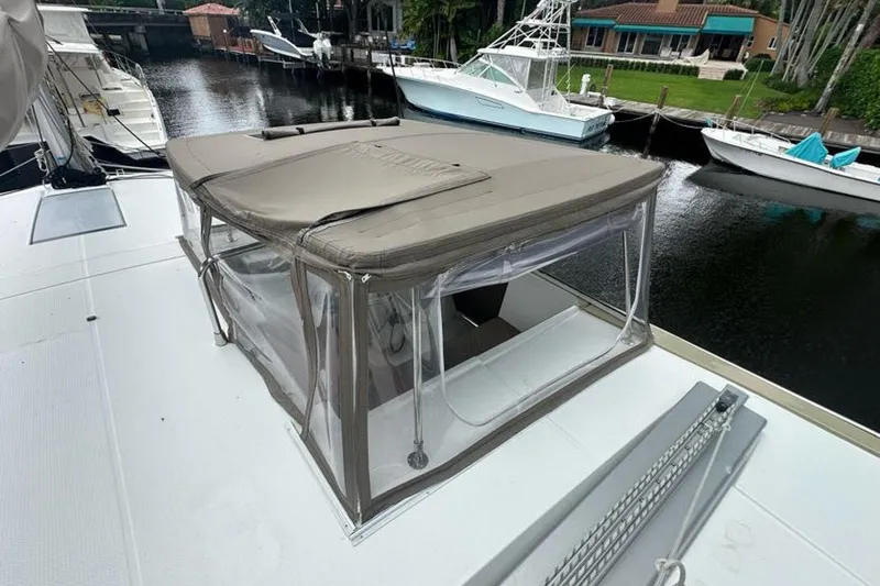 Slide: The Image of 2017 Fountaine Pajot Lucia 40 catamaran with covered cockpit, docked near other boats. - 20