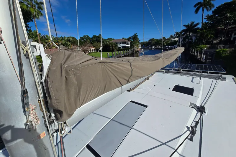 Slide: The Image of 2017 Fountaine Pajot Lucia 40 catamaran deck with covered sail, docked in a scenic canal. - 29