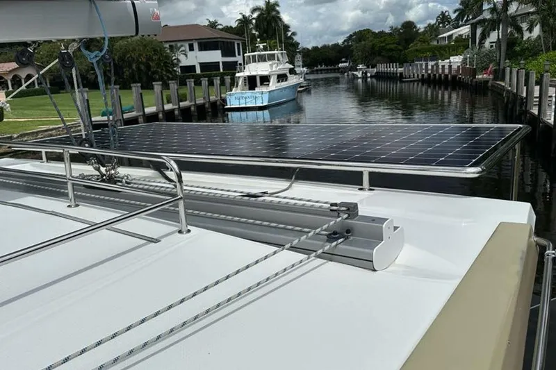 Slide: The Image of 2017 Fountaine Pajot Lucia 40 catamaran with solar panels docked in a scenic canal. - 30