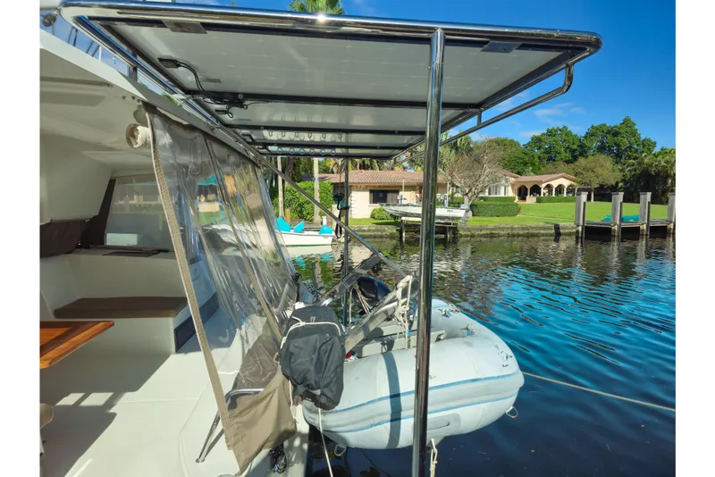 Slide: The Image of 2017 Fountaine Pajot Lucia 40 catamaran with dinghy, docked by waterfront property. - 34