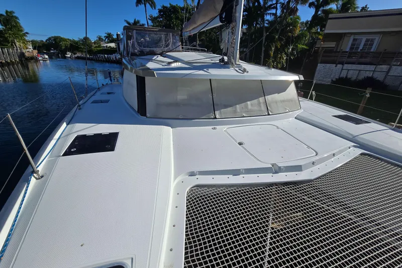 Slide: The Image of 2017 Fountaine Pajot Lucia 40 catamaran docked, showcasing sleek deck design and netting. - 4