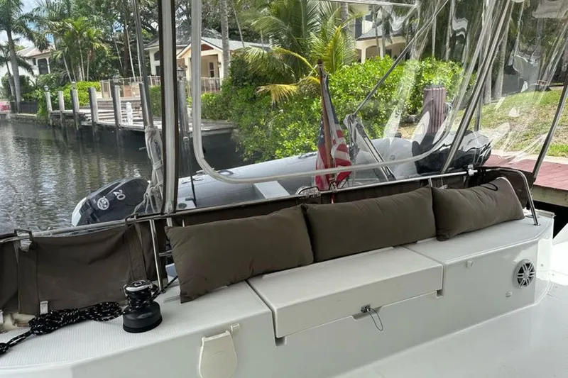 Slide: The Image of 2017 Fountaine Pajot Lucia 40 catamaran with seating area, docked by lush greenery. - 44