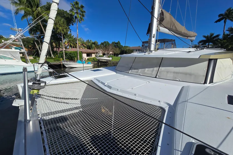 Slide: The Image of 2017 Fountaine Pajot Lucia 40 catamaran docked, featuring spacious deck and netting. - 5