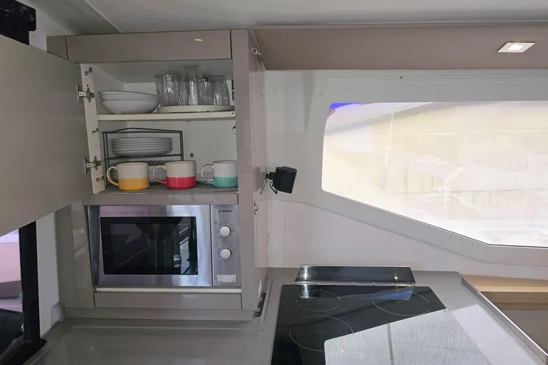 Slide: The Image of Modern kitchen interior of 2017 Fountaine Pajot Lucia 40 catamaran with microwave and colorful mugs. - 59