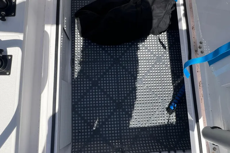 Slide: The Image of Storage compartment on a 2021 Axopar 28 boat with a black bag and blue strap. - 10
