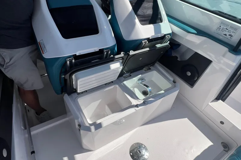 Slide: The Image of 2021 Axopar 28 boat interior with open storage compartment and sink. - 11