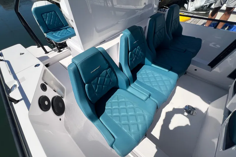 Slide: The Image of 2021 Axopar 28 boat interior with teal diamond-stitched seats and modern design. - 18