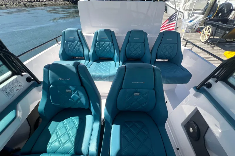 Slide: The Image of 2021 Axopar 28 boat interior with blue quilted seats and American flag. - 19