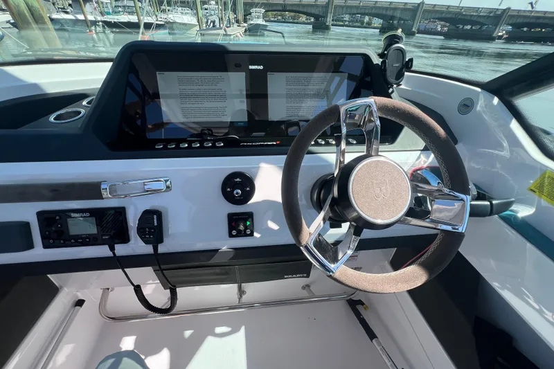 Slide: The Image of 2021 Axopar 28 boat dashboard with steering wheel and navigation controls. - 23