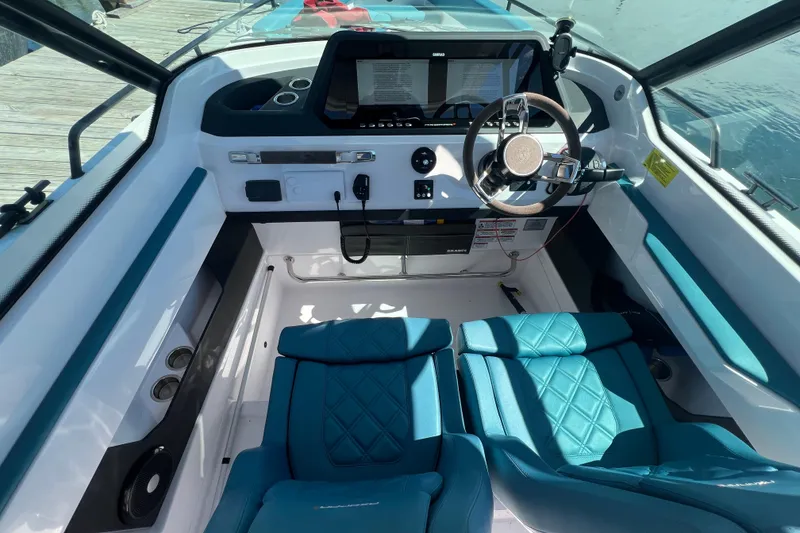 Slide: The Image of 2021 Axopar 28 boat interior with modern dashboard and blue seating. - 24