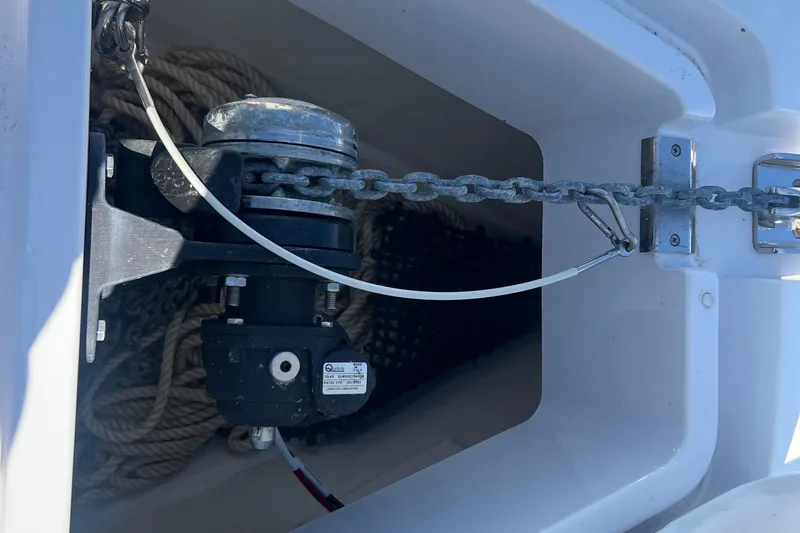 Slide: The Image of Anchor chain mechanism on a 2021 Axopar 28 boat, featuring a winch and secured chain. - 29