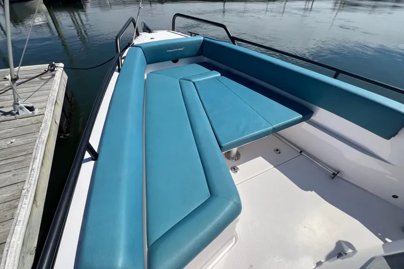 Slide: The Image of 2021 Axopar 28 boat with blue seating, docked by the water. - 31