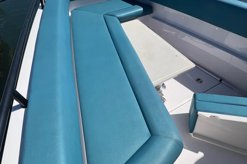 Slide: The Image of 2021 Axopar 28 boat with blue seating and a white table. - 32