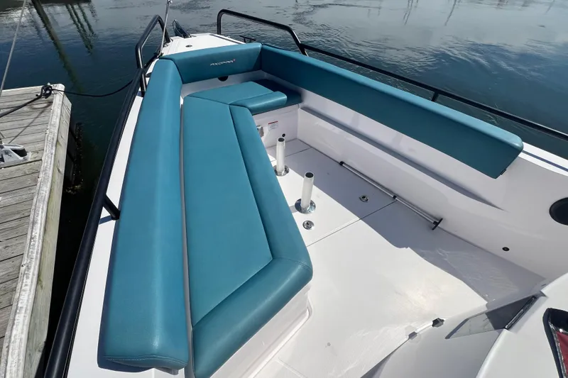 Slide: The Image of 2021 Axopar 28 boat with teal seating, docked by the water. - 33