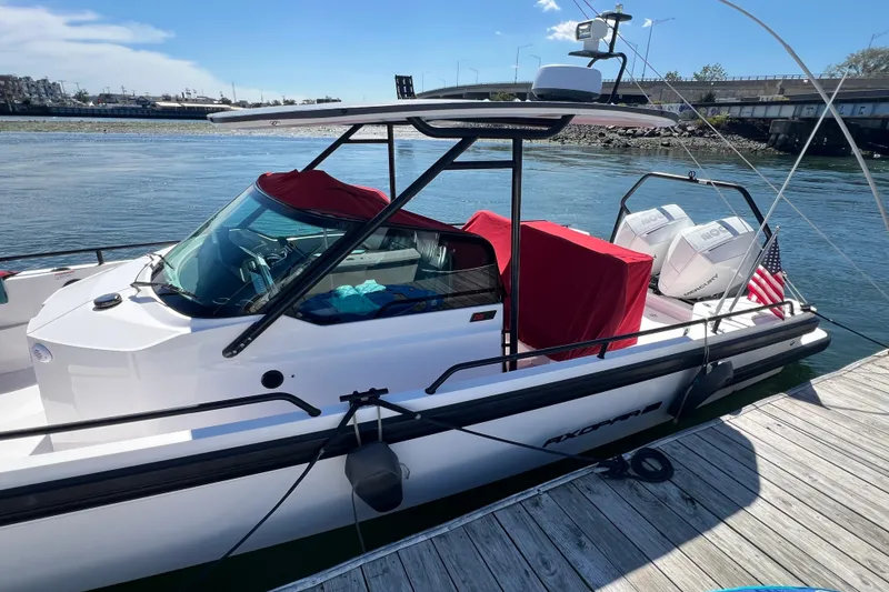 Slide: The Image of 2021 Axopar 28 boat docked, featuring red covers and twin engines. - 4