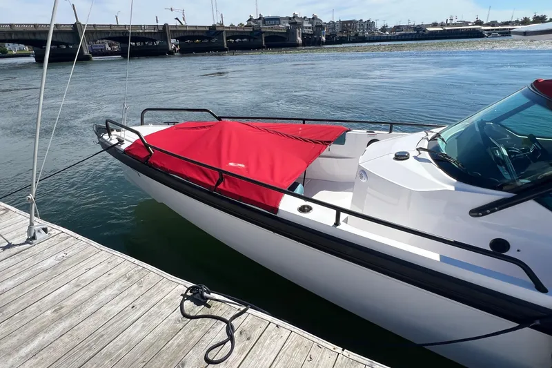 Slide: The Image of 2021 Axopar 28 boat docked, featuring a red cover and sleek design. - 5