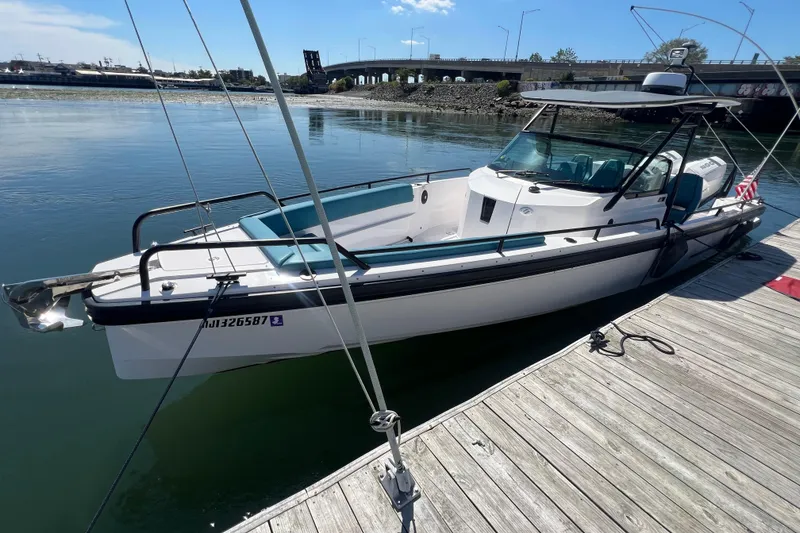 Slide: The Image of 2021 Axopar 28 boat docked on calm water near a bridge. - 6