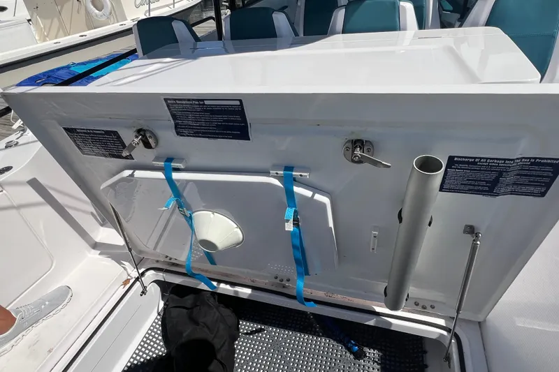 Slide: The Image of 2021 Axopar 28 boat storage compartment with safety equipment and instructions. - 9