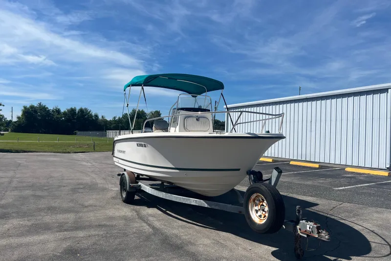 Slide: The Image of 2001 Trophy 1903 Center Console boat on trailer, parked outdoors under blue sky. - 2