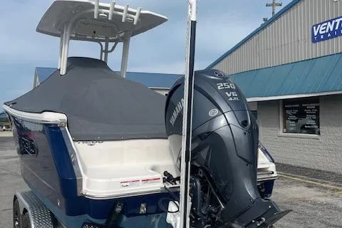 Slide: The Image of 2023 Robalo R230 Center Console boat with Yamaha 250 V6 engine, parked outside a building. - 15