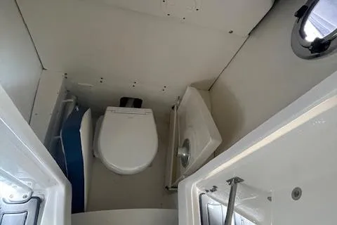 Slide: The Image of 2023 Robalo R230 Center Console boat interior with compact marine toilet. - 6