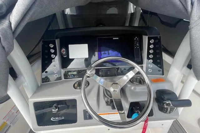 Slide: The Image of 2023 Robalo R230 Center Console boat dashboard with steering wheel and controls. - 8