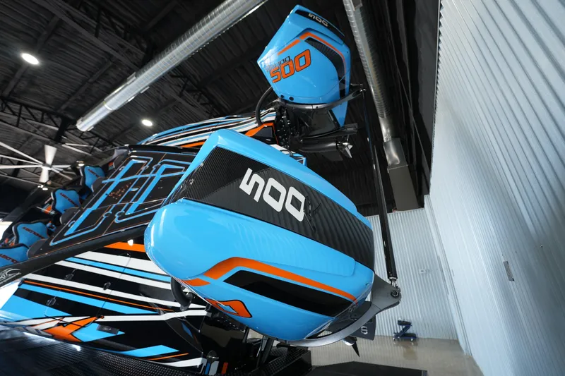 Slide: The Image of 2025 MTI 440X boat with vibrant blue and orange design in a modern garage. - 10