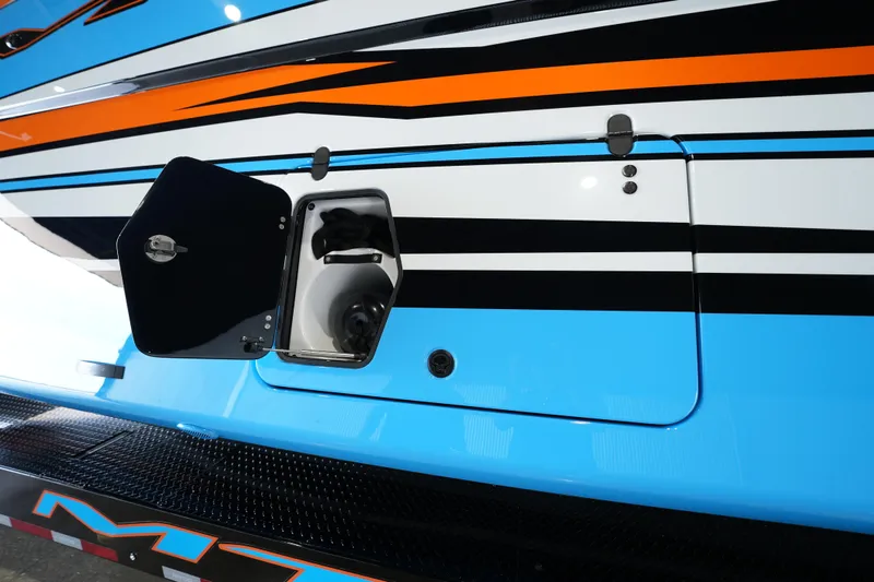 Slide: The Image of 2025 MTI 440X boat with vibrant blue, orange, and black stripes, featuring an open hatch. - 14