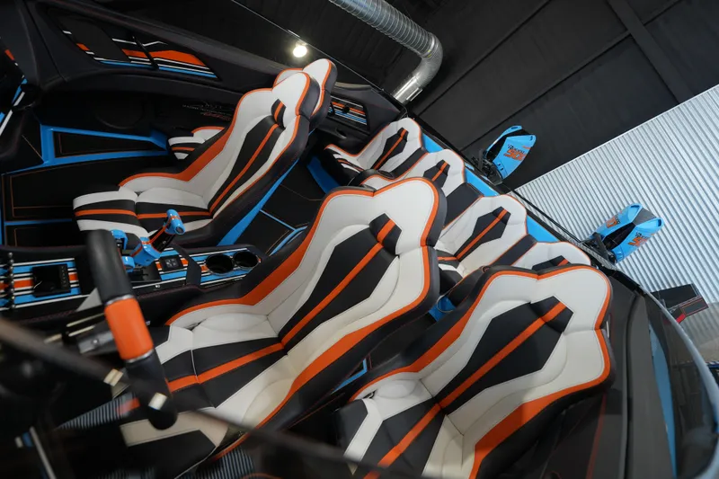 Slide: The Image of Futuristic MTI 440X 2025 interior with vibrant orange, black, and white racing seats. - 16