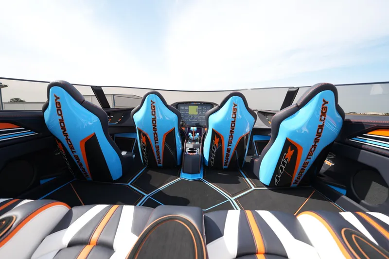 Slide: The Image of Interior of 2025 MTI 440X boat with blue and orange seats, modern dashboard. - 23