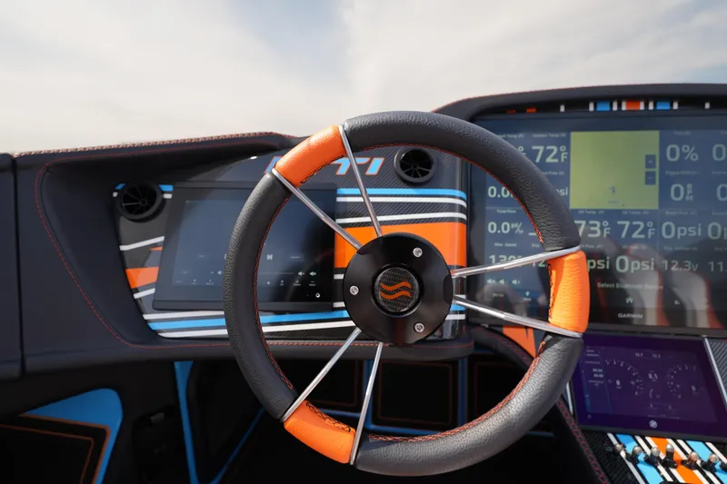 Slide: The Image of Steering wheel and dashboard of 2025 MTI 440X boat, featuring vibrant colors and digital displays. - 36
