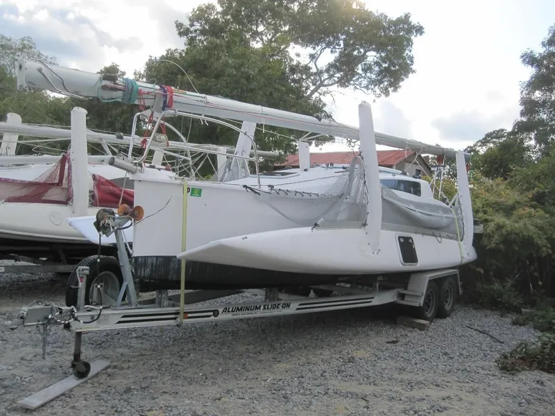 Slide: The Image of 2010 Corsair Dash 750 sailboat on trailer, parked outdoors with trees in background. - 3