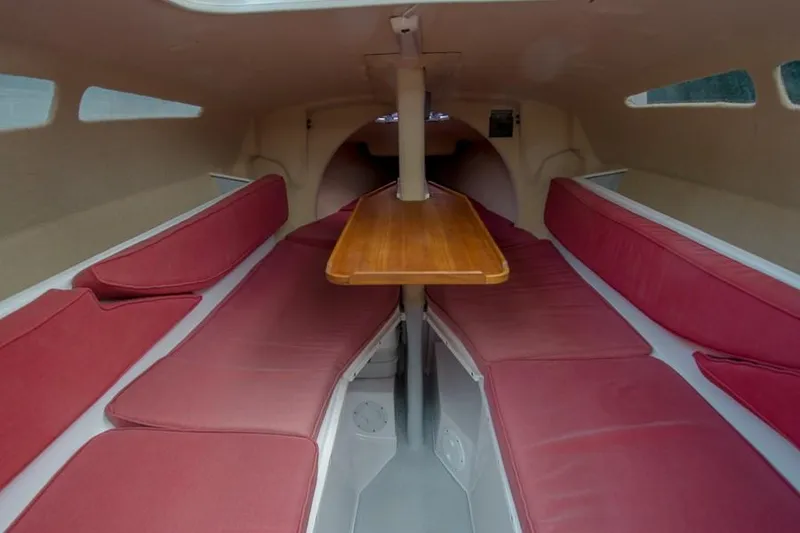 Slide: The Image of Interior of 2010 Corsair Dash 750 sailboat with red seating and wooden table. - 5