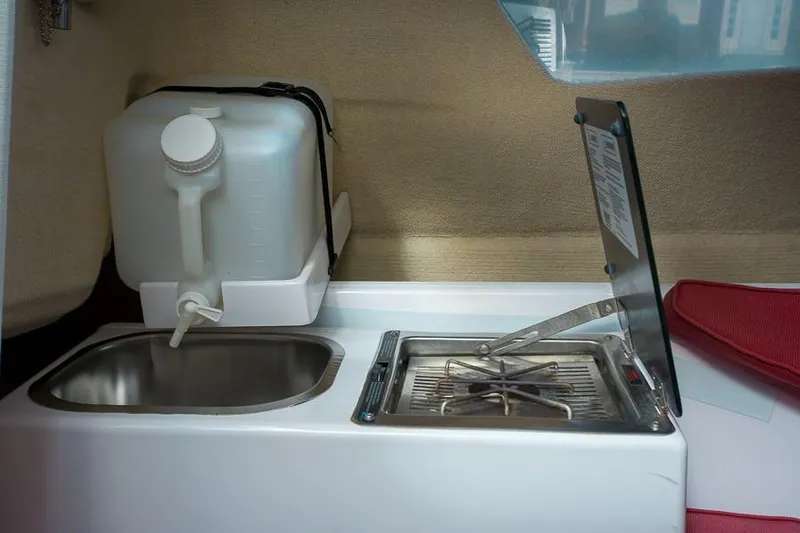 Slide: The Image of Compact kitchen area in a 2010 Corsair Dash 750 sailboat with sink and stove. - 9