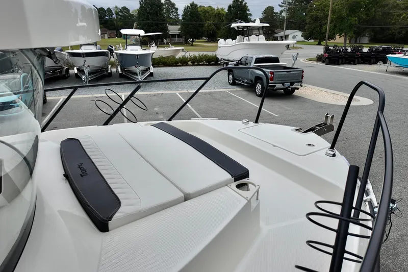 Slide: The Image of 2026 Bayliner Trophy T25 Pilothouse boat deck with seating, parked in a marina. - 11