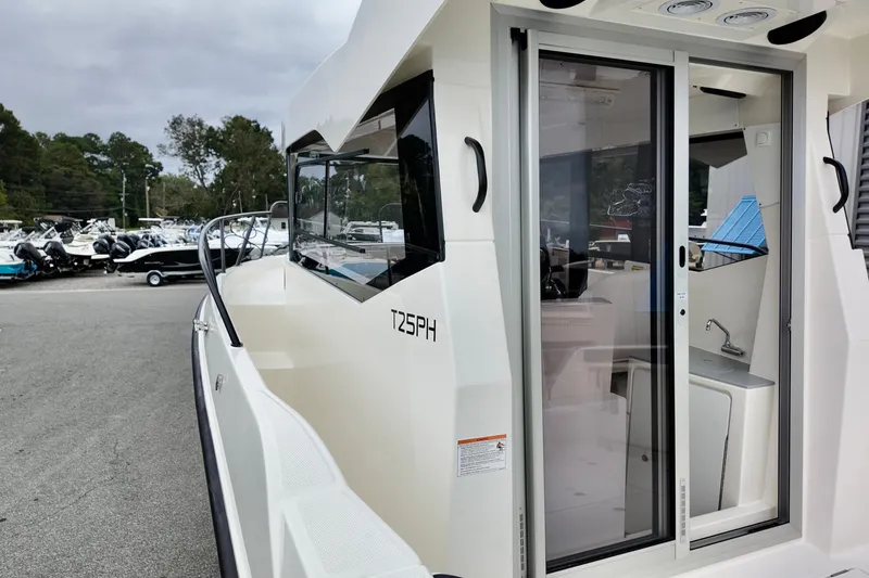 Slide: The Image of 2026 Bayliner Trophy T25 Pilothouse boat with sliding glass door and sleek design. - 14