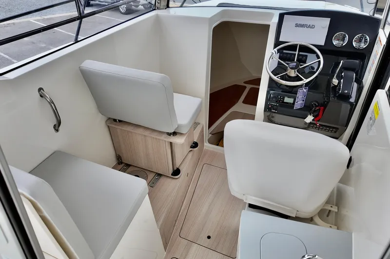 Slide: The Image of 2026 Bayliner Trophy T25 Pilothouse interior with steering wheel and seating. - 23