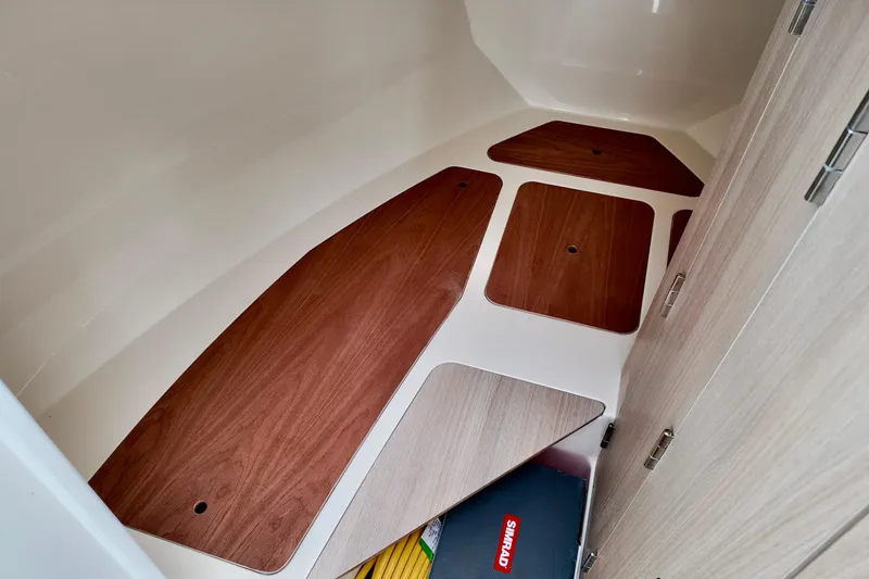 Slide: The Image of 2026 Bayliner Trophy T25 Pilothouse interior with wooden flooring and storage compartments. - 31