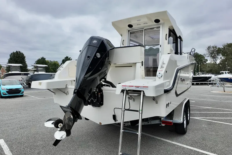 Slide: The Image of 2026 Bayliner Trophy T25 Pilothouse boat with outboard motor in parking lot. - 4