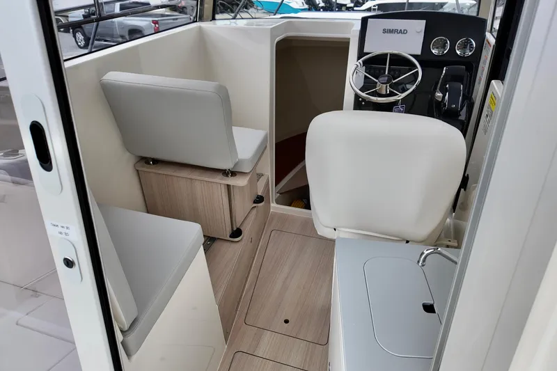 Slide: The Image of 2026 Bayliner Trophy T25 Pilothouse interior with steering wheel and seating. - 8