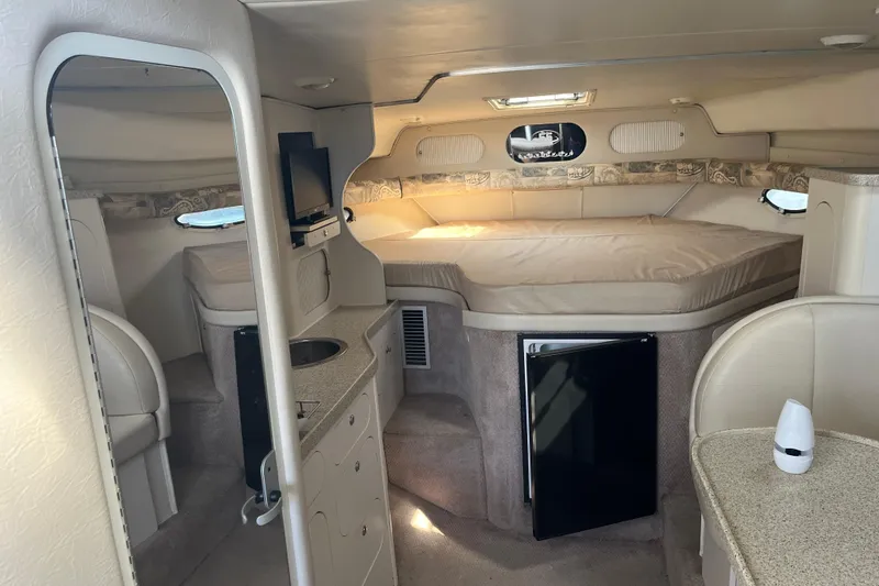 Slide: The Image of Interior of 2000 Rinker 340 Fiesta Vee boat with bed, kitchenette, and seating area. - 28