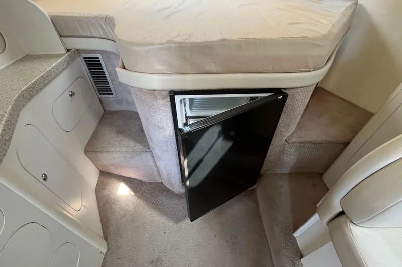 Slide: The Image of Interior of 2000 Rinker 340 Fiesta Vee with open mini fridge and beige upholstery. - 38