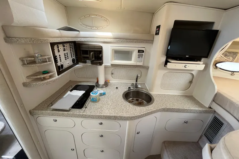 Slide: The Image of 2000 Rinker 340 Fiesta Vee boat interior with kitchenette, sink, and TV. - 40