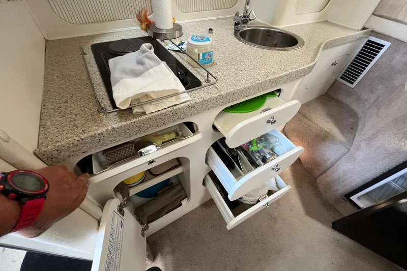 Slide: The Image of Compact kitchen area in a 2000 Rinker 340 Fiesta Vee boat with storage and sink. - 43